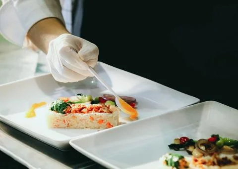 Chef cooking, Chef preparing food, Chef decorating dish in the kitchen Stock Photos