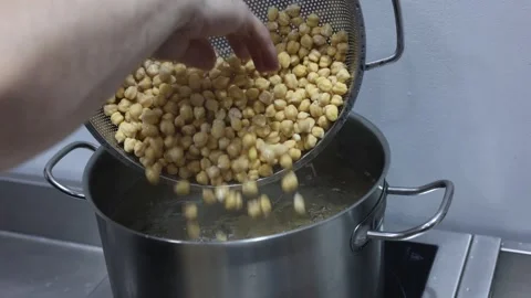 Chef cooking chickpeas in boiling water pot Stock Footage 329318679
