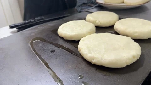 Chef cooking colombian arepas on a griddle in a restaurant kitchen 動画素材 344100061