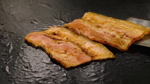 Chef cooking a crispy grilled bacon strips on the frying surface with oil Stock Footage 76952431