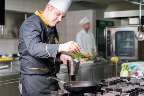 Chef Cooking, Cutting and preparing next plate Stock Photos