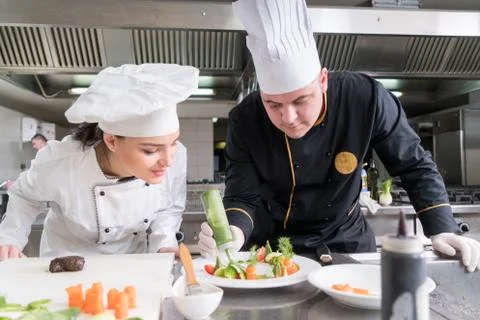 Chef Cooking, Cutting and preparing next plate Stock Photos