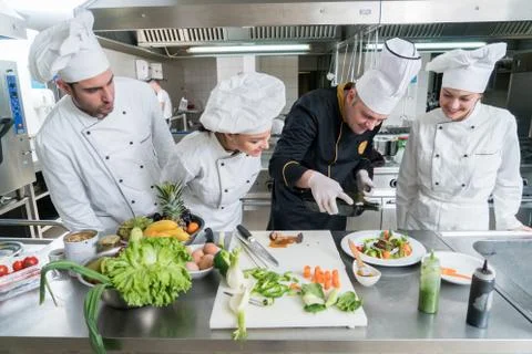 Chef Cooking, Cutting and preparing next plate Stock Photos