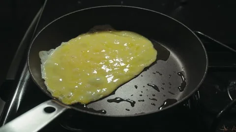 Chef cooking delicious scrambled eggs in a skillet Vídeo Stock 338306103