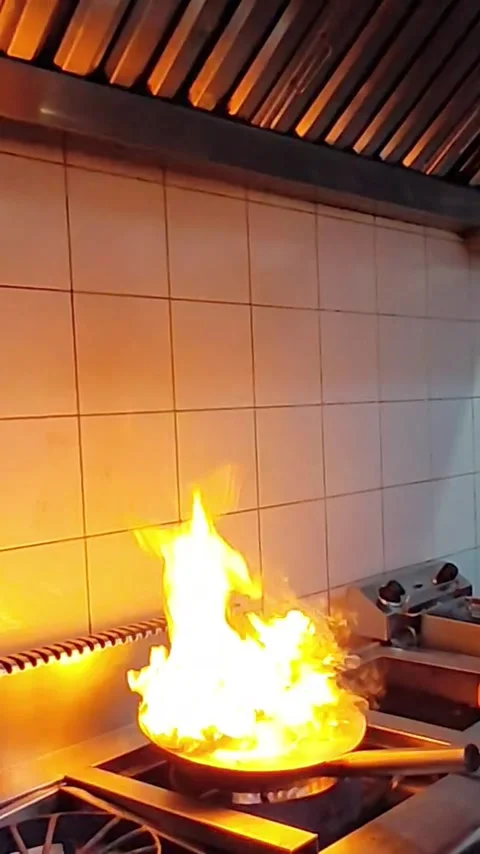 Chef cooking dish with high open flame in wok pan in restaurant kitchen Stock Footage 340111263