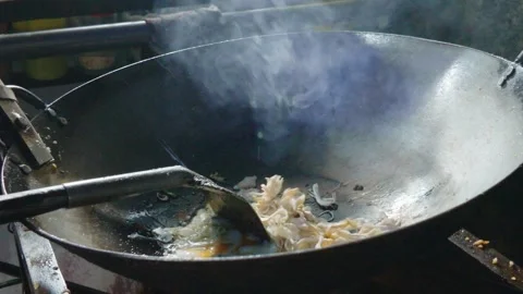 Chef cooking egg for delicious street food in a large wok with steam rising. 库存影片 343408079