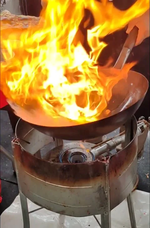 Chef cooking with fire in frying pan on street food Stock Footage 323651570