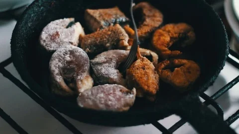Chef is cooking fish in a frying pan until golden brown Stock Footage