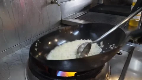 Chef Cooking Freshly Prepared Fried Rice in a Hot Wok on a High-Flame Stove 스톡 동영상 332814529