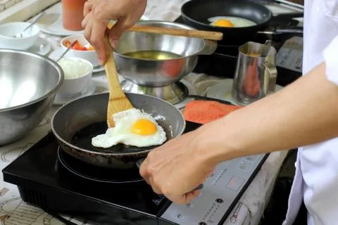 Chef cooking fried eggs Stock Photos