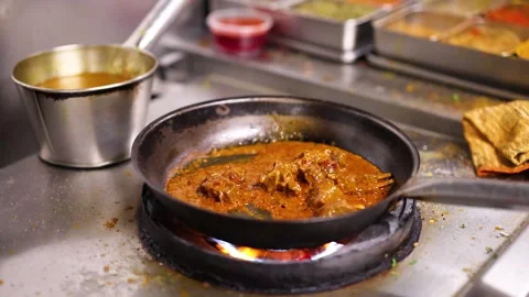 Chef Cooking Indian Curry in Frying Pan on Gas Stove Stockbeeldmateriaal 337519097