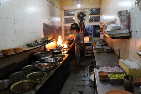 A chef cooking in a kitchen with lots of pots. Stock Photos