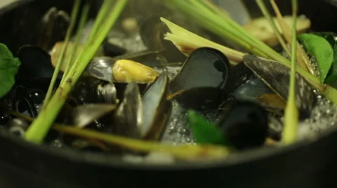 Chef cooking mussels in a pot with different types of herbs in oriental style Video stock 68632094
