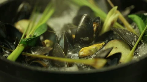 Chef cooking mussels in a pot with different types of herbs in oriental style Stock Footage 68632100
