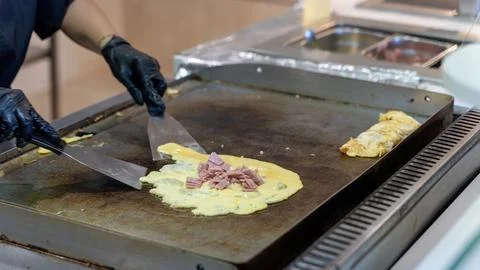 Chef Cooking Omelet with Ham on Flat Top Grill Stock Photos
