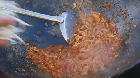 Chef cooking Pad Thai stir-fried rice noodles in pan Stock Footage