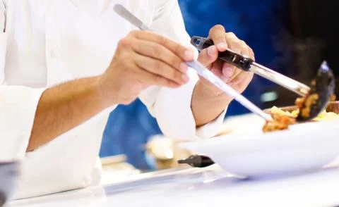 Chef cooking pasta, Chef serves spaghetti carbonara on the plate in the kitch Stock Photos