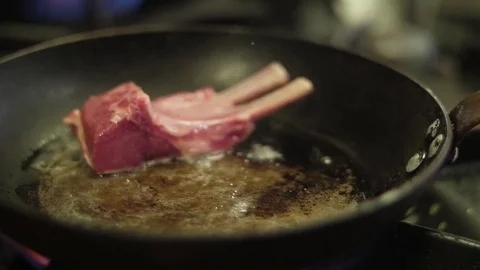 Chef cooking rack of lamb in the frying pan slow motion Stock Footage 78583248