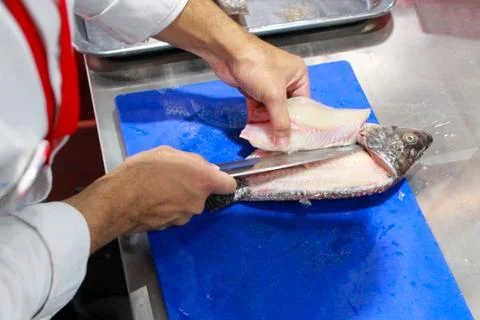 Chef cooking raw fish on kitchen, Process of cooking fish Stock-Fotos