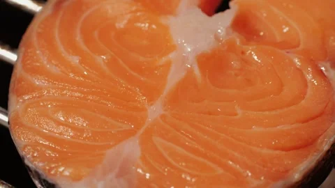 Chef cooking red salmon fish steaks with oil and spices on grill close-up Stock Footage 270020034