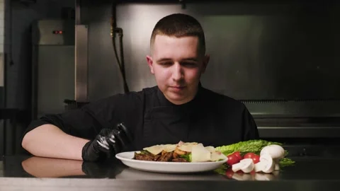 Chef is cooking in a restaurant kitchen. Handsome man makes salad in the kitchen Stock Footage 232531751