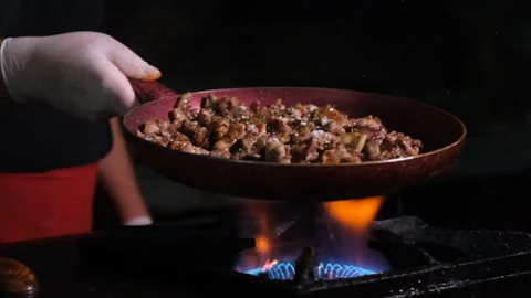 Chef cooking in a restaurant, mixing in pan while cooking Stock Footage 247997090