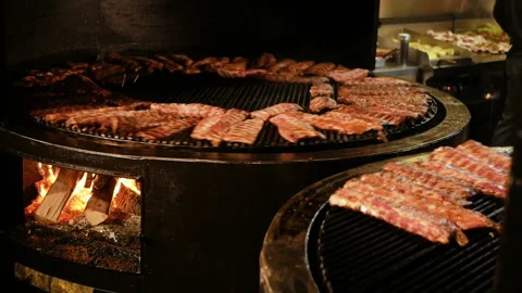 Chef cooking ribs on grill. appetizing pork ribs rotate on cast iron grill Stock Footage 94368456