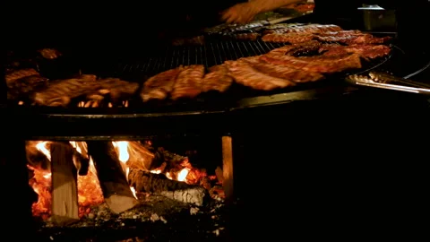 Chef cooking ribs on grill. appetizing pork ribs rotate on cast iron grill Stock Footage 94369143