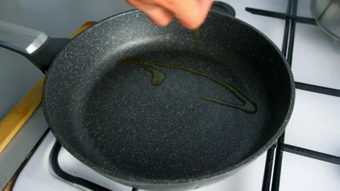 Chef cooking skillfully pouring olive oil into frying pan on kitchen. Video stock 312467635