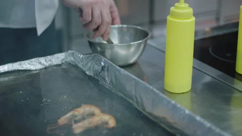 A Chef cooking some prawn in a griddle Stock Footage 283013083