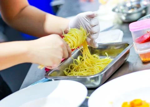 Chef cooking spaghetti in the kitchen, Chef putting Spaghetti to the plate Stock Photos