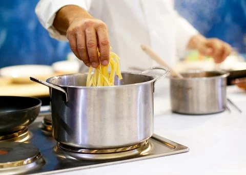 Chef cooking spaghetti in the kitchen Stock Photos