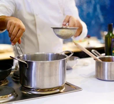 Chef cooking spaghetti in the kitchen Stock Photos
