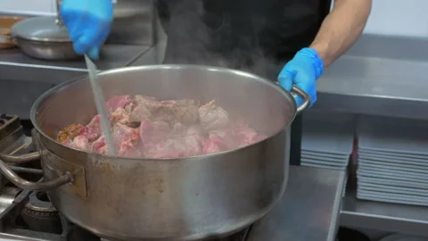 Chef cooking a stew on a pot or saucepan Stock Footage 149756627