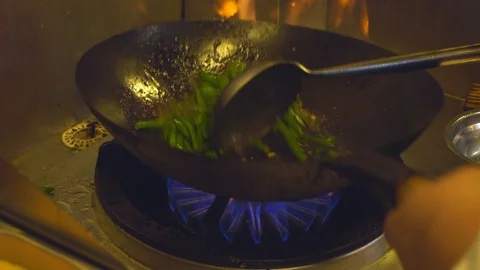 Chef cooking traditional Chinese food in a wok in slow motion Stock Footage