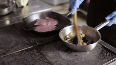 Chef cooking a vegetables and steak in commercial kitchen Stock Footage 68850876