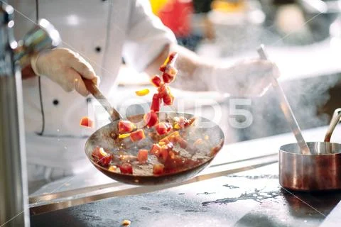 Chef cooking vegetables in wok pan. Shallow dof. Stock Photos