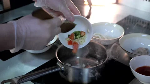 Chef cooks appetizing soup from vegetables, shrimps, squids, suace. Seafood soup Stock Footage 132828230