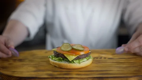 Chef cooks burger and puts rings of red onion into it , making burgers at the Stock Footage 106803502