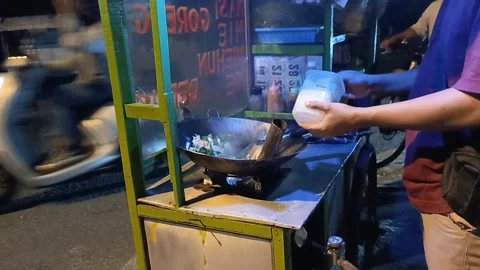 The chef cooks fried vermicelli by adding the spices to the pan Stock Footage 287326473