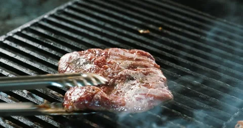 Chef cooks grilled meat, changing side. Grill pork and beef preparing on coals Stock Footage 135796171