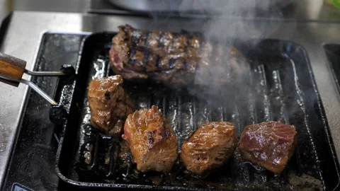 A chef cooks meat in a frying pan. raw meat in a hot frying pan or on a grill. Stock Footage 336626749