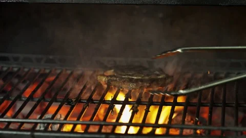 Chef cooks meat on the grill in the restaurant Video stock 79711055