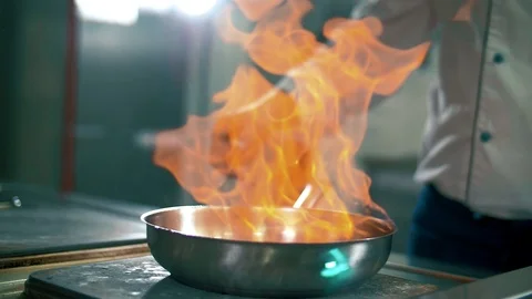 Chef cooks meat on an open fire in the kitchen on the stove in the pan Stock Footage 102662194