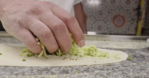 Chef cooks pide, put the stuffing grated cheese and pistachios on the dough Stock Footage 264013125