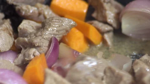 A chef cooks raw beef with vegetables, close up Stock Footage 135412891