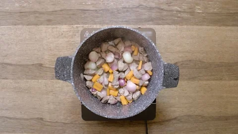 A chef cooks raw beef with vegetables, top view Stock Footage 135427202