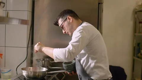 A chef cooks vegetables on a pan in a restaurant. Video stock 277131607