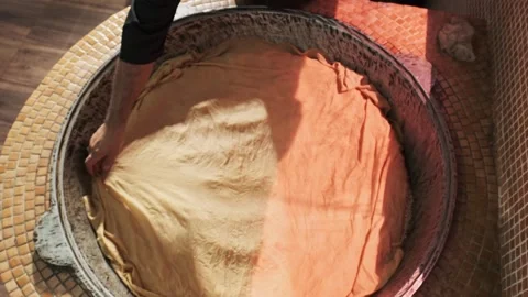 Chef covers steaming rice with a cloth in a large pilaf cauldron Stock Footage 254570364