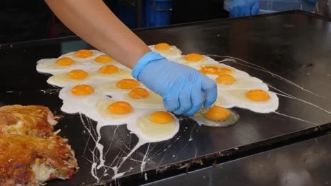 Chef Cracking and Cooking Multiple Fried Eggs on Large Street Food Griddle Stock-Footage 347688924